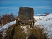 Off-road vozidlo prechádzajúce zasneženým terénom počas zimného dobrodružstva.