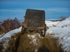 Off-road vozidlo prechádzajúce zasneženým terénom počas zimného dobrodružstva.