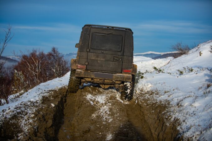 Off-road vozidlo prechádzajúce zasneženým terénom počas zimného dobrodružstva.